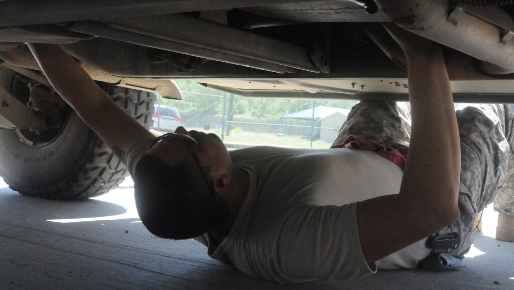 Mechanic inspecting a used Humvee before purchase